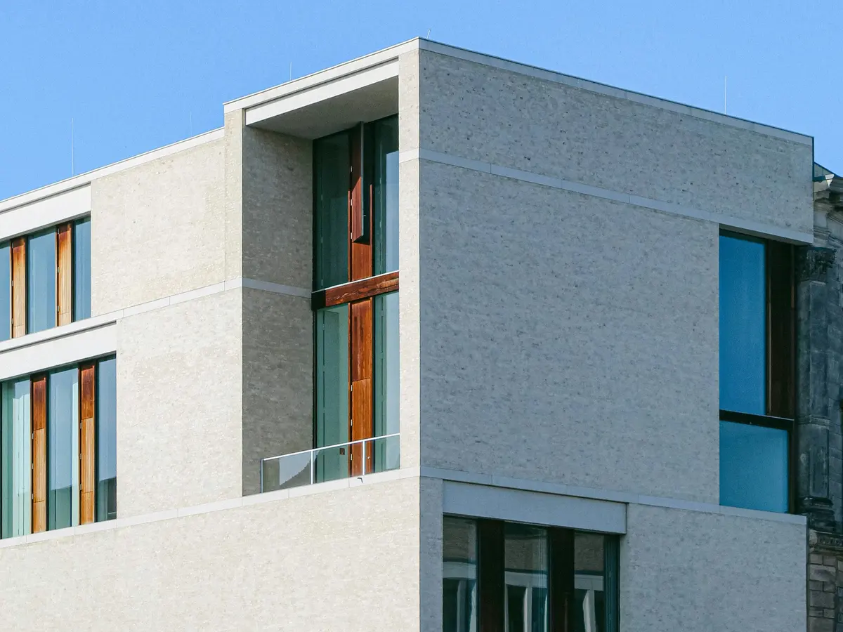 Fachada de edifício comercial com revestimento claro e esquadrias verticais