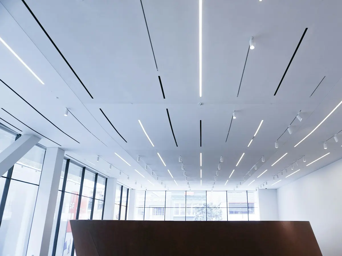 Interior comercial amplo com forro linear e iluminação embutida