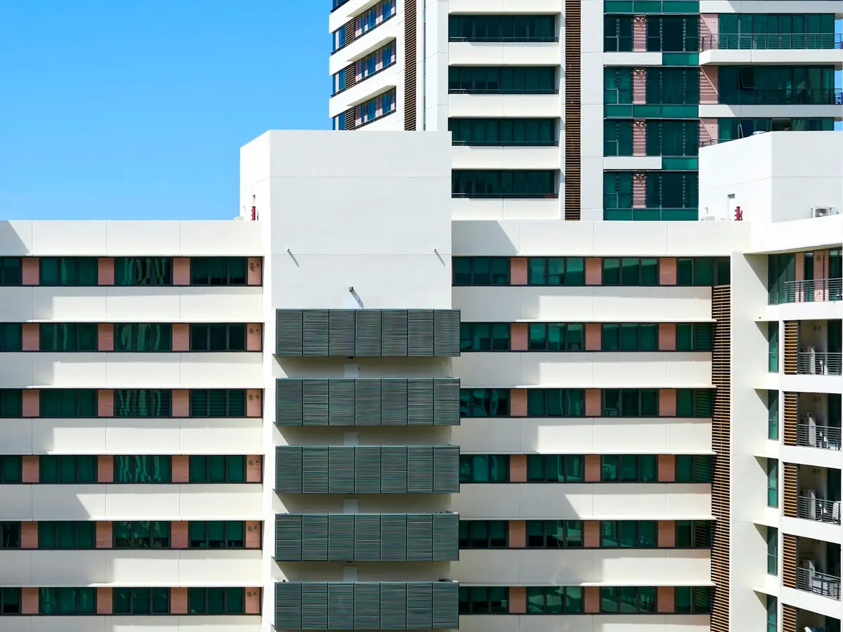 Edifício multifamiliar de fachada branca e janelas em faixa